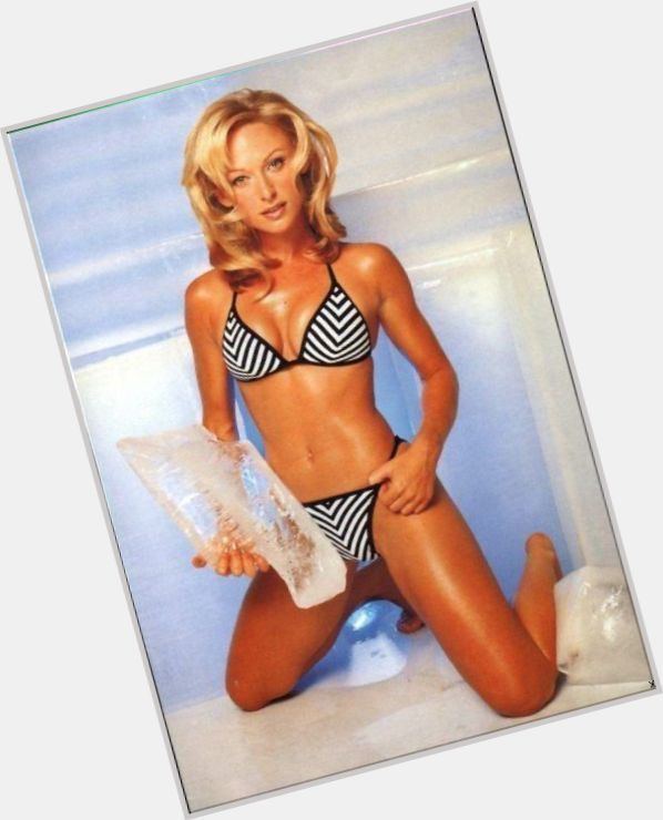 Terasa Livingstone with a serious face, wavy blonde hair, and wearing a black and white two-piece while holding a block of ice.