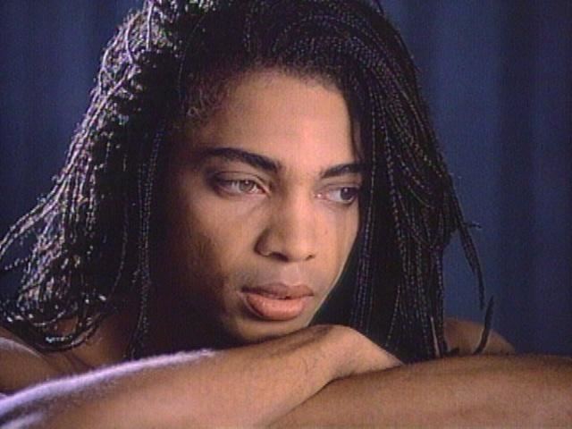 Terence Trent D'Arby looking at something while his face is leaning on his arms