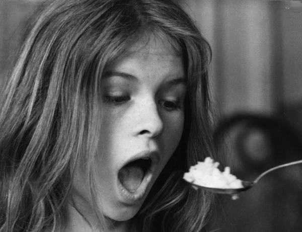 Teresa Ann Savoy opening her mouth and being fed with a spoon of rice as Clotilde in the 1974 film "Le Farò Da Padre"