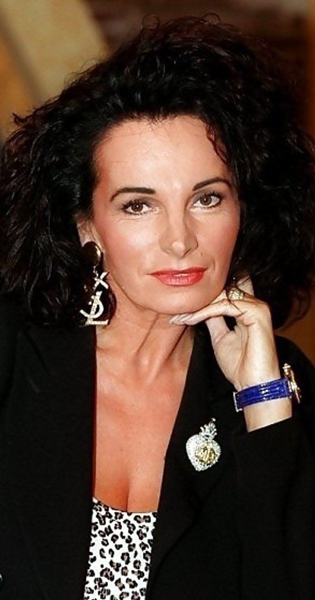 Smiling Teresa Orlowski wearing a black coat and a purple watch