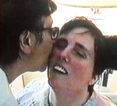 Mary Schindler kissing her daughter, Terri Schiavo on the cheeks while she is wearing a white blouse
