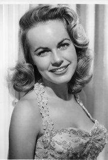 Smiling Terry Moore in black and white wearing a dress