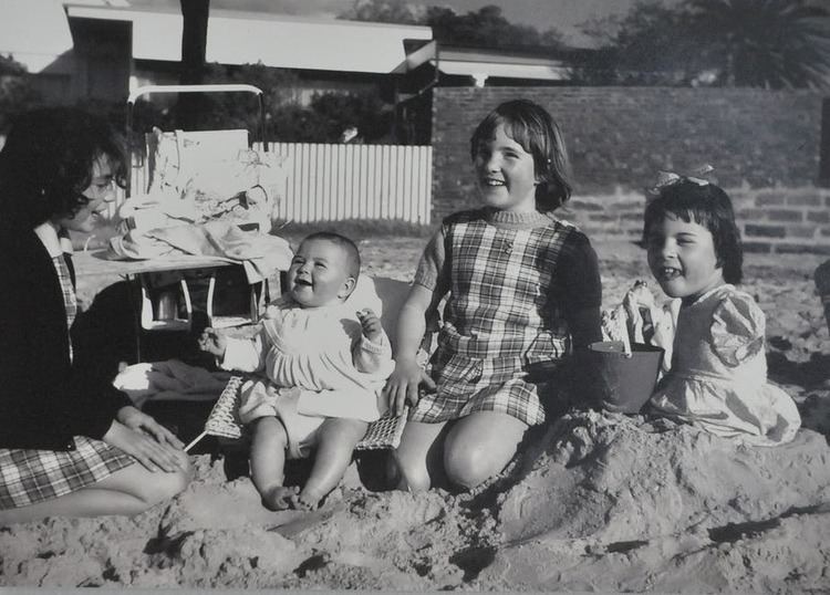 Children playing happily and a girl on the right having no arms and hands