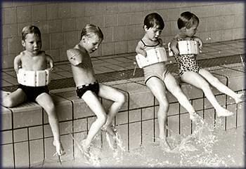 A group of children sitting by the pool having short arms and hands