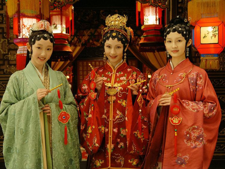 The casts of The Dream of Red Mansions, Mengjie Jiang, Yi Song, and Li Qin are smiling, with kunqu-inspired hairdo, and wearing hanfu dresses.