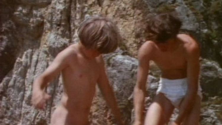 Two children taking their clothes off in a scene from the movie "The Genesis Children" (1972 film)