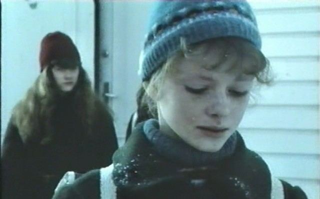 Line Storesund crying while wearing a blue beanie, jacket, and turtle-neck blouse in a movie scene from the 1987 film The Ice Palace