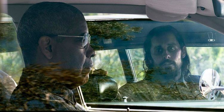 Jared Leto riding in a car and looking at Denzel Washington facing to the front while driving in another car
