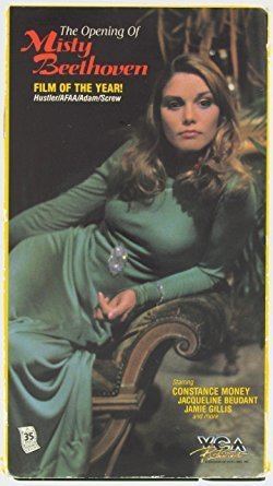Constance Money sitting on a couch and wearing a blue dress in a poster of the 1976 film "The Opening of Misty Beethoven" featuring