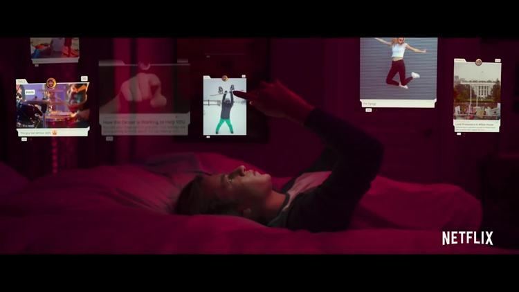 Skyler Gisondo lying on the bed while browsing on different social media platforms in a scene from the 2020 docudrama film, The Social Dilemma