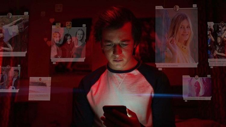 Skyler Gisondo browsing on different social media platforms while wearing a black and white shirt in a scene from the 2020 film, The Social Dilemma