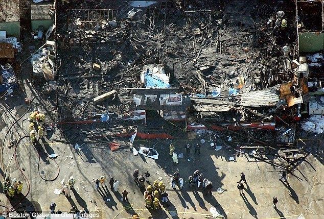 Station nightclub fire scene, viewed from above and of the front door. The one-story building burned to the ground in about three minutes. The fire was started by pyrotechnics going off on the stage while the band Great White performed. As seen, firefighters, medics, and police officers are still on the scene to clear the area.