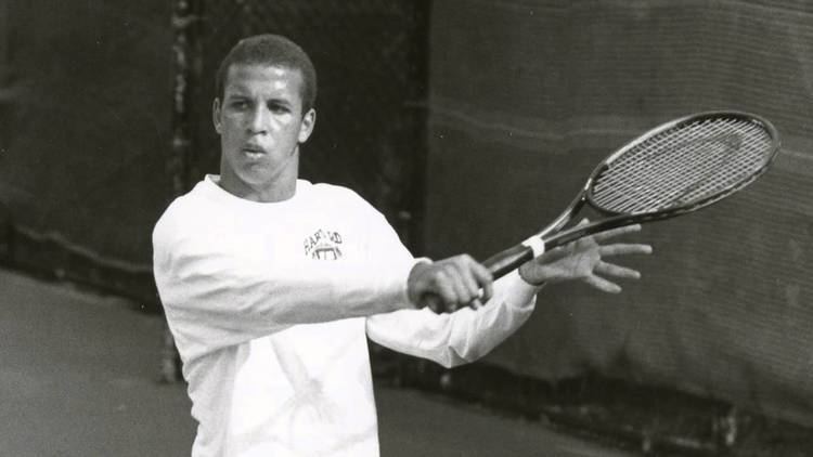 Thomas Blake playing tennis while wearing a long sleeve shirt