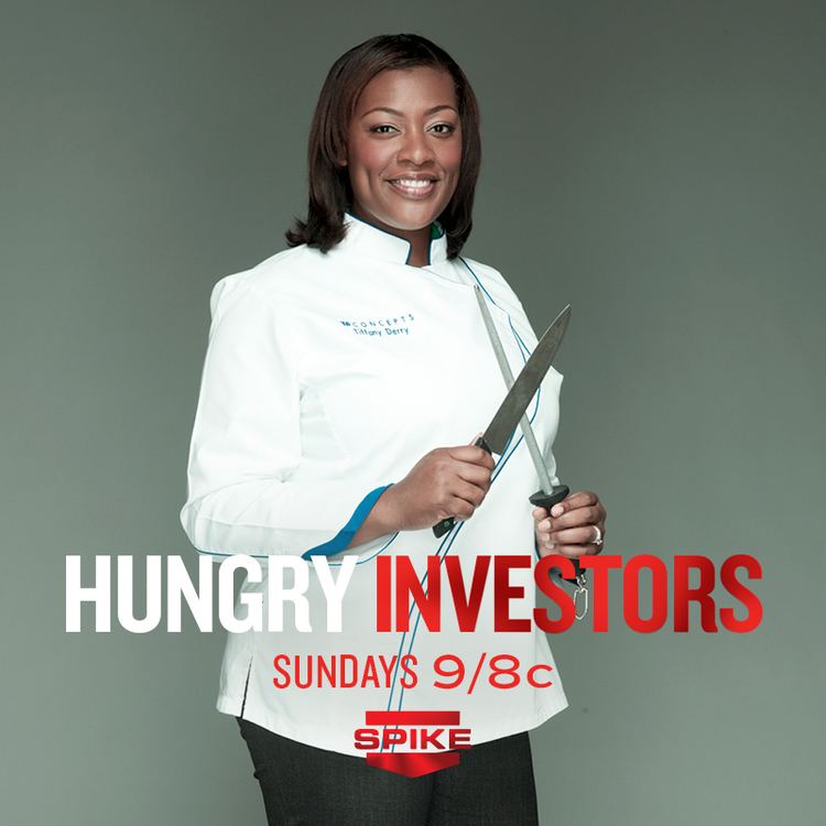 Poster of Hungry Investors featuring Tiffany Derry smiling while holding a knife and a sharpening rod, with shoulder-length hair and wearing a white chef gown with her name on it and black pants.