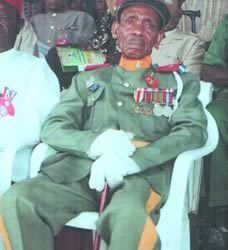 Timothy Onwuatuegwu wearing his uniform while sitting on a chair
