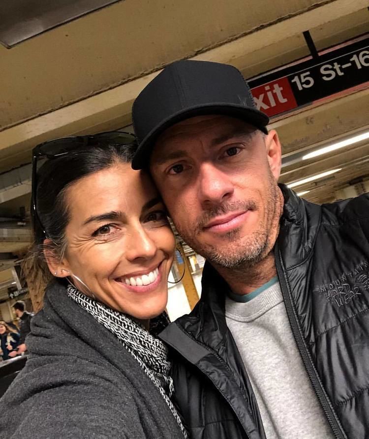 Tina Caspary smiling and wearing a scarf and black blazer while Ryan Cyphert wearing a black cap, black jacket, and gray shirt