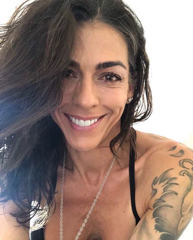 Tina Caspary smiling and wearing a black top and necklace