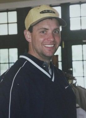 Todd Beamer smiling while wearing a brown cap and black and white t-shirt