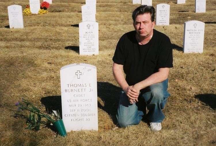 Tom Burnett's grave visited by the man who is wearing a black t-shirt and denim pants