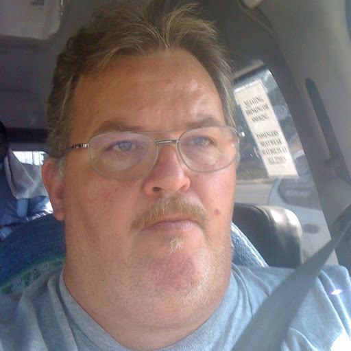 Tom Eplin inside the car wearing gray t-shirt and eyeglasses