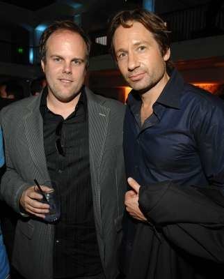 Tom Kapinos in his gray coat and black long sleeves and David Duchovny in his blue long sleeves