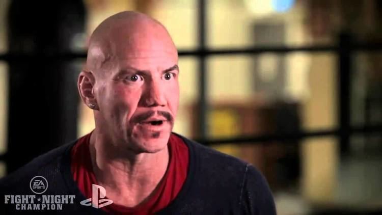 Tommy Morrison in one of his interviews while wearing black sweatshirt and red inner shirt