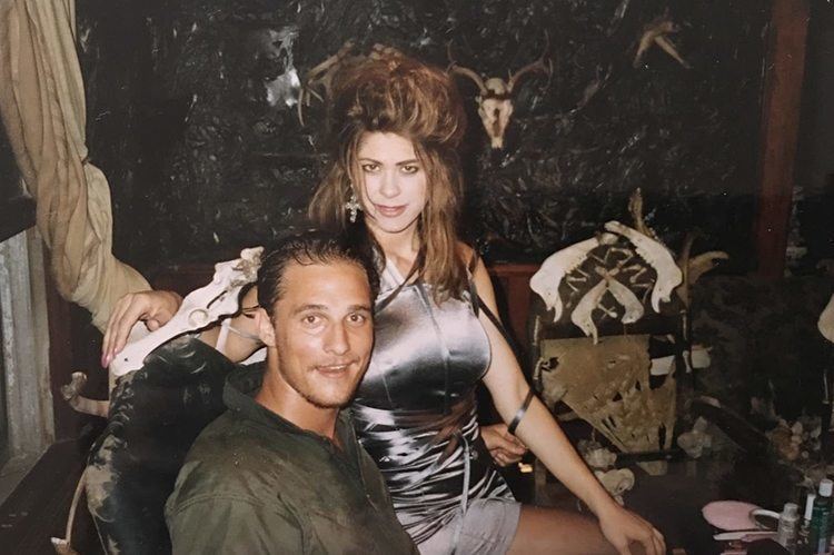 Matthew McConaughey and Tonie Perensky smiling together on the set of Texas Chainsaw Massacre: The Next Generation while Tonie is wearing a gray dress