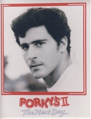 Poster of Porky's II, The Next Day featuring Tony Ganios with a serious face and wearing a white shirt.