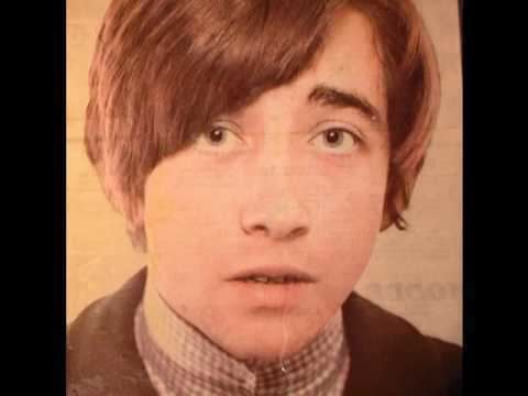 Tony Hicks with a shocked face while wearing a gray turtle-neck shirt under a black coat