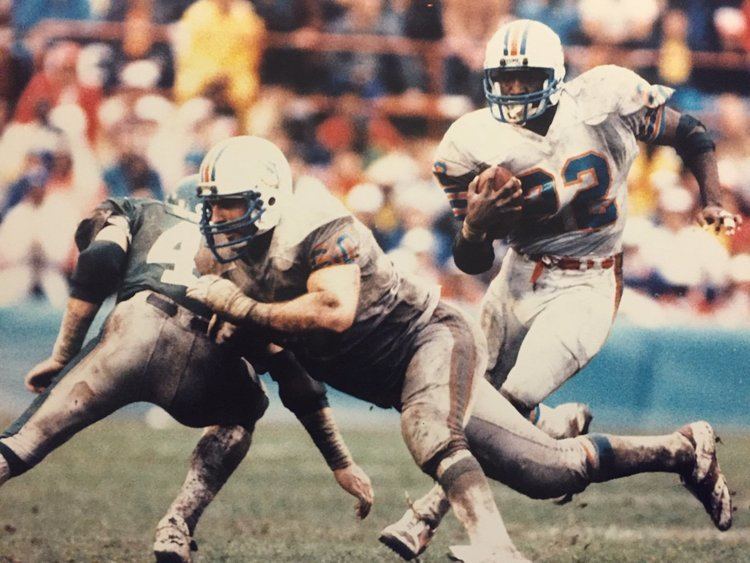 Tony Nathan running behind Miami Dolphins guard Jeff Toews during a game against the New York Jets