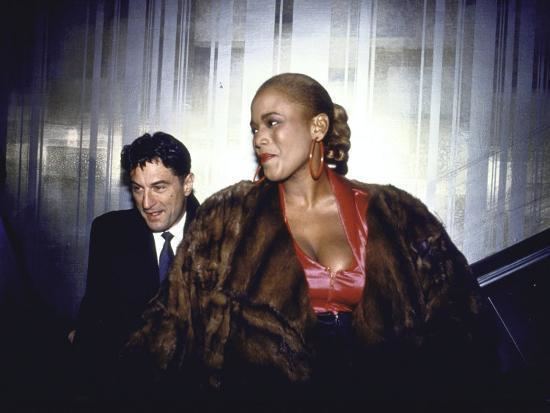 Toukie Smith in her braided hair with Robert De Niro who is wearing black coat, white long sleeves and neck tie