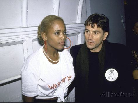 Robert De Niro wearing black coat and black inner shirt with Toukie Smith wearing white shirt and jewelries