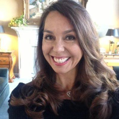 Tracie Ruiz smiling while wearing a black blouse and necklace