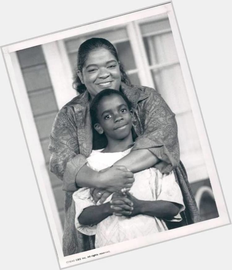 Trent Cameron at a young age, wearing a white shirt with Nell Carter smiling and wearing a blazer while hugging Trent.
