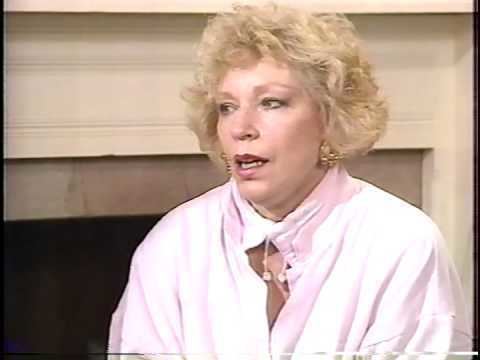 Truddi Chase speaking in an interview and wearing a white dress.