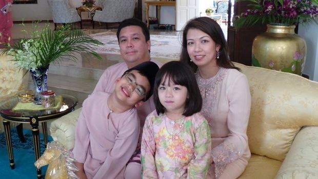 Tunku Abdul Majid with his family sitting on a couch.