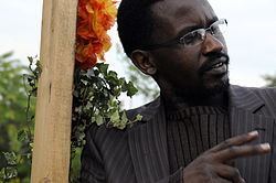 A Tutsi man wearing eyeglasses and a striped suit.