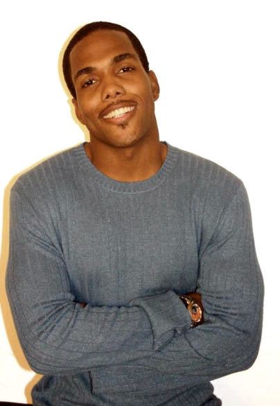 Tyrone D. Burton smiling and wearing gray sweatshirt