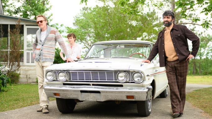 Paul Bettany as Frank, Peter Macdissi as Wally, and Sophia Lillis as Beth standing beside a car in a movie scene from Uncle Frank, a 2020 American comedy-drama film.