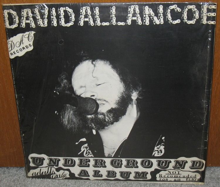 The Underground Album by David Allan Coe. David is singing while closing his eyes in front of a microphone and wearing a black shirt with a white print.