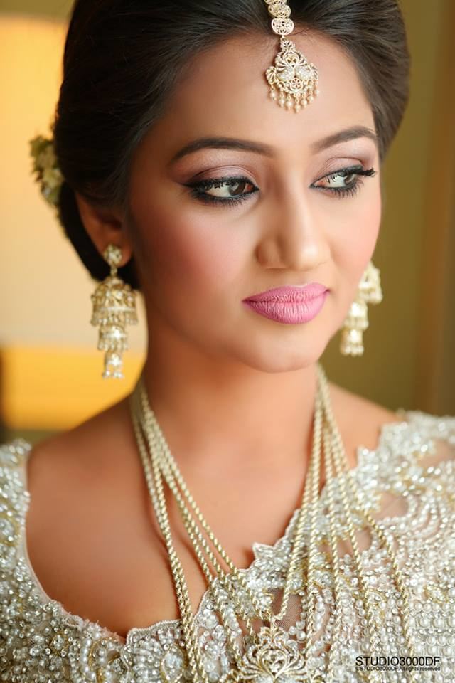 Upeksha Swarnamali posing beautifully with pink lipstick and wearing a white gown along with assorted white jewelries.