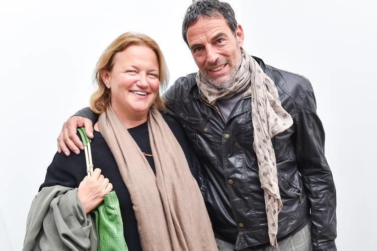 Uri Fruchtmann smiling and wearing a beige scarf and black leather jacket while Alix Marcaccini wearing a brown scarf and black blouse