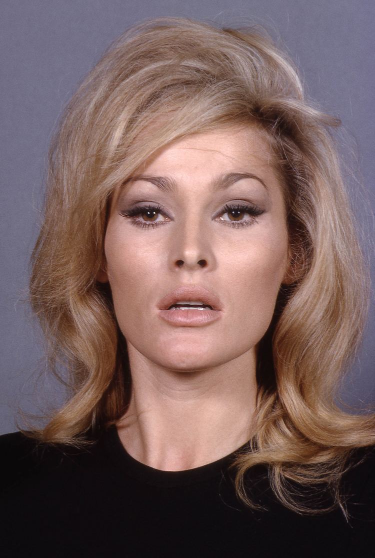 Ursula Andress posing with her mouth open and wearing a black shirt.