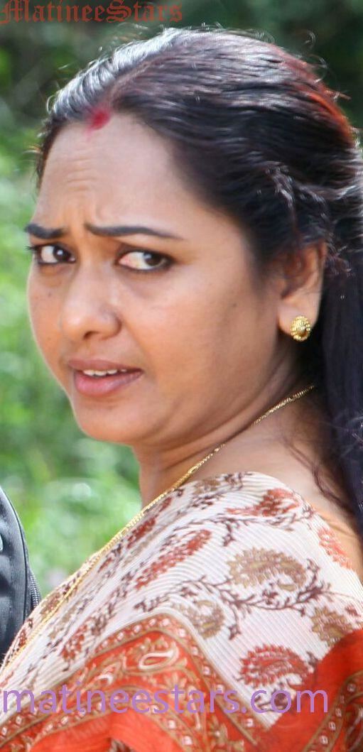 Usha (actress) wearing an orange dress, gold earrings, and necklace