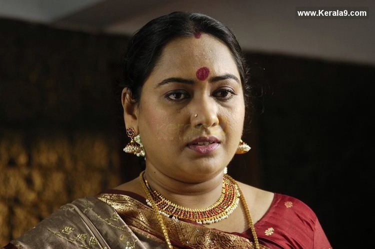 Usha (actress) wearing a red dress, earrings, and necklaces