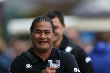 Va'aiga Tuigamala smiling and holding a water bottle as he arrived in London for the Rugby Aid 2015 celebrity match wearing a black T-shirt with white coloured logos.