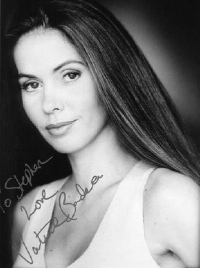 Vaitiare Bandera with a tight-lipped smile while wearing a sleeveless blouse and an autograph on the lower left