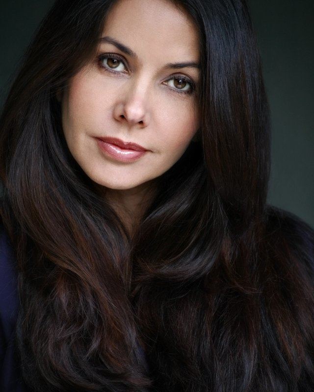 Vaitiare Bandera with a tight-lipped smile while wearing a black blouse