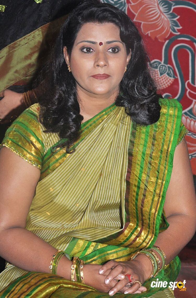 Vani Viswanath with wavy black hair, wearing bracelets, rings, and color green traditional Indian clothing.