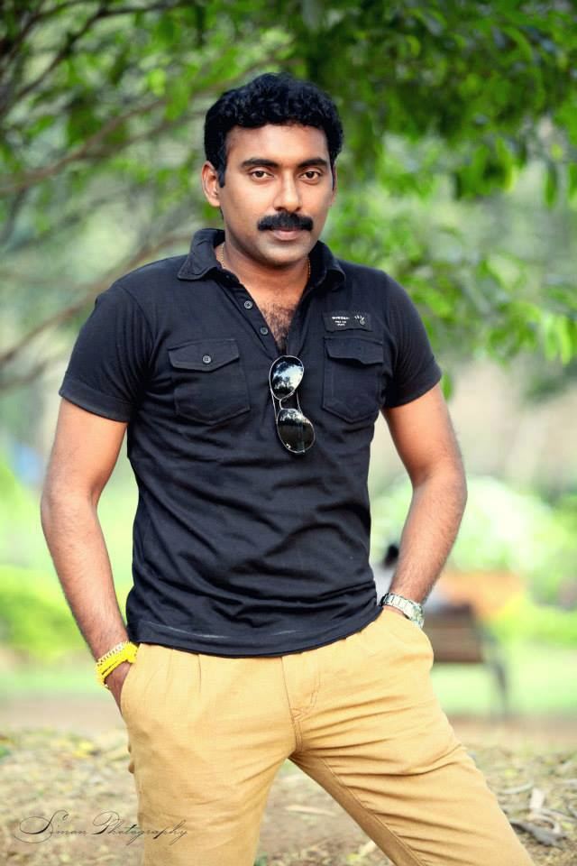 Vankayalapati Veera Sesha Murali Krishna's hands on his pocket while wearing a black polo shirt, khaki pants, wristwatch, and bracelet